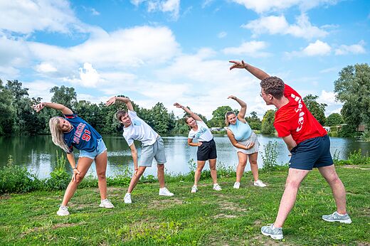 Jugendliche machen Dehn�bungen mit Animateur auf Camping CAPFUN De Rotonde in Enspijk.