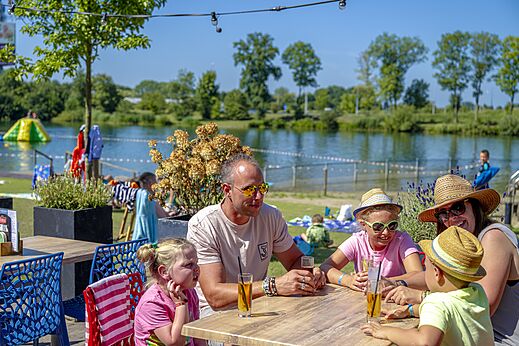 Familie isst auf Restaurantterrasse am Campingplatz CAPFUN De Rotonde in Enspijk.