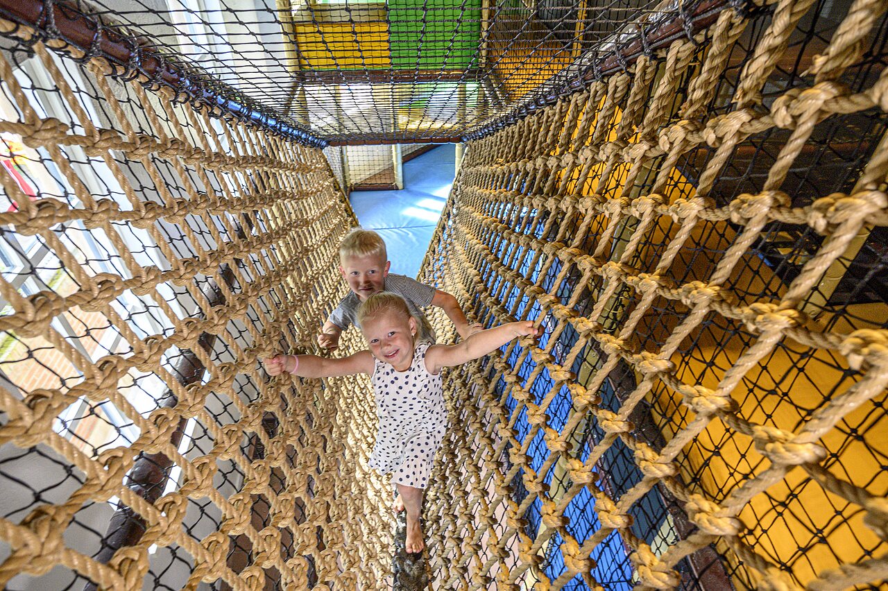 Kinder spielen in Seiltunnel auf Camping CAPFUN De Scheepsbel in Doornspijk.