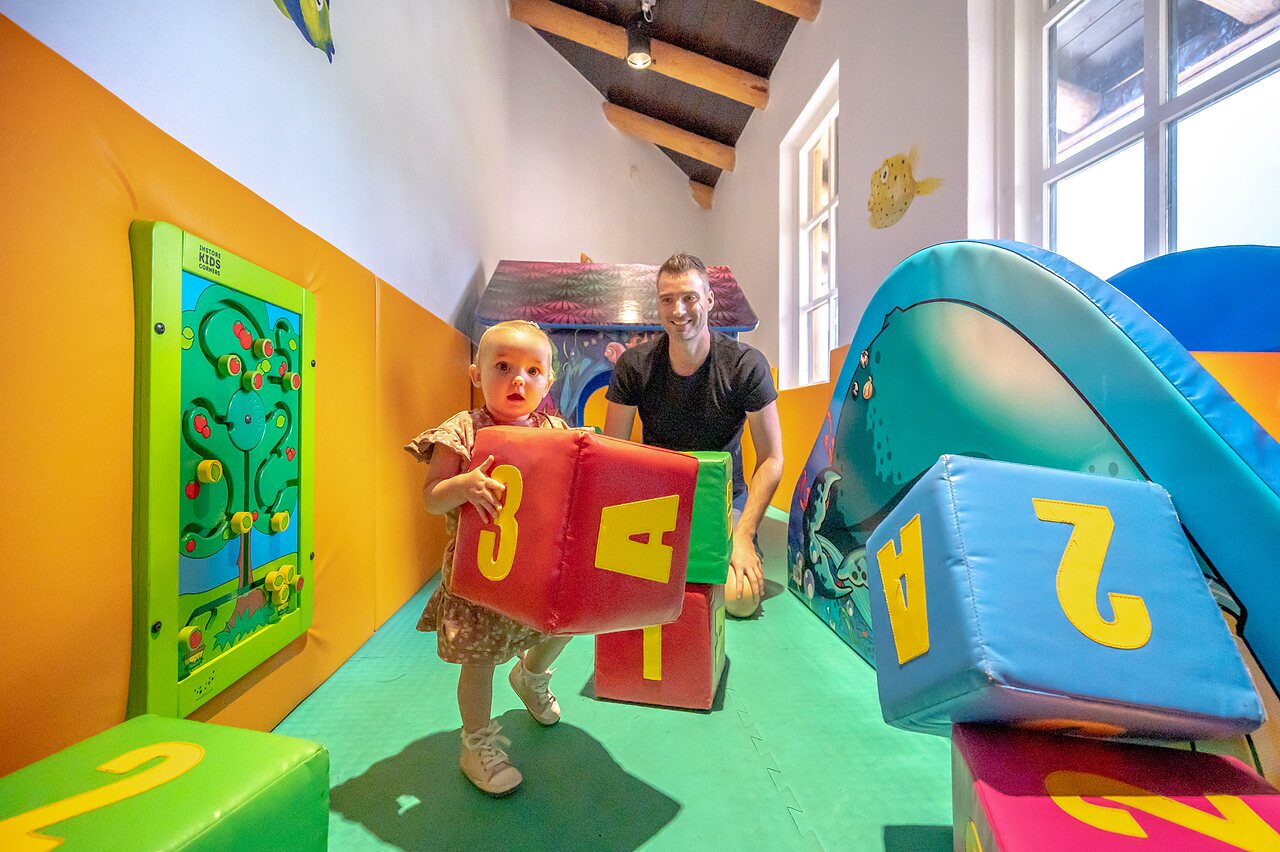 Indoor-Spielplatz mit Baby und Erwachsenem im Camping CAPFUN De Scheepsbel in Doornspijk.