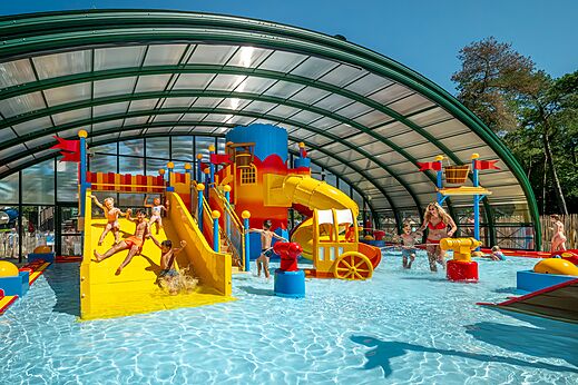 Überdachtes Schwimmbad mit Wasserspielen und Rutschen im CAPFUN De Scheepsbel.
