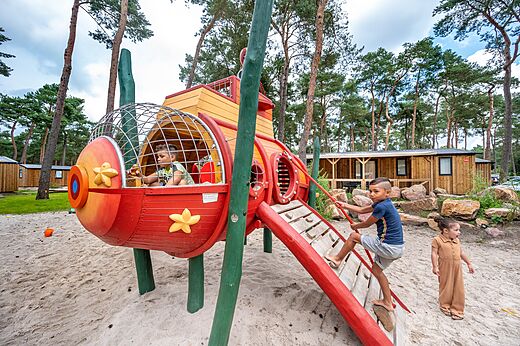 Farbenfroher Spielplatz mit Kindern auf dem Campingplatz CAPFUN De Scheepsbel in Doornspijk.