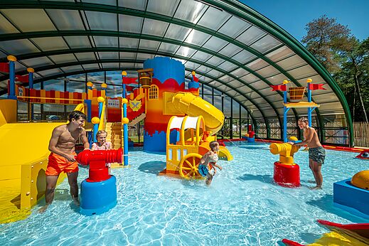 �berdachter Wasserspielplatz mit Rutschen und Wasserkanonen auf dem Campingplatz CAPFUN De Scheepsbel in Doornspijk.