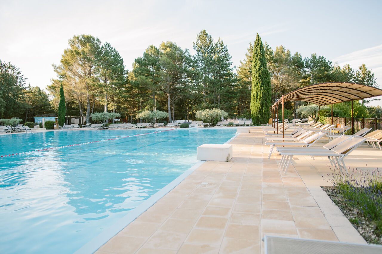 Gro�er Au�enpool mit Liegest�hlen und Schattenbereich auf dem Campingplatz LIBRANOO Naturiste Belezy in B�doin (84).