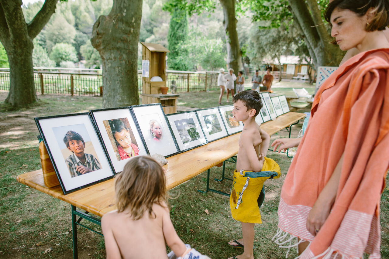 Kinder betrachten Fotoausstellung im Freien auf Camping LIBRANOO Naturiste Belezy in B�doin (84).