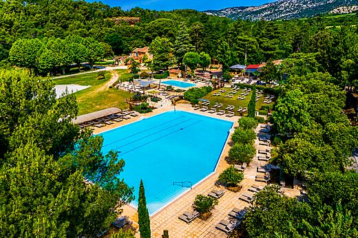 Großer Wasserpark mit mehreren Pools aus der Vogelperspektive auf dem Campingplatz LIBRANOO Naturiste Belezy in Bédoin (84).
