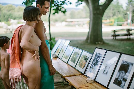 Naturistische familie bekijkt foto-expositie op camping LIBRANOO Naturiste Belezy, Bédoin.