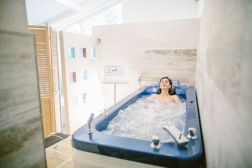 Vrouw ontspant in een hydrotherapiebad op camping LIBRANOO Naturiste Belezy in Bédoin (84).