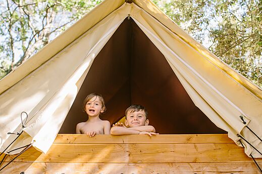 Lachende kinderen in houten glampingtent op camping LIBRANOO Naturiste Belezy in Bédoin (84).