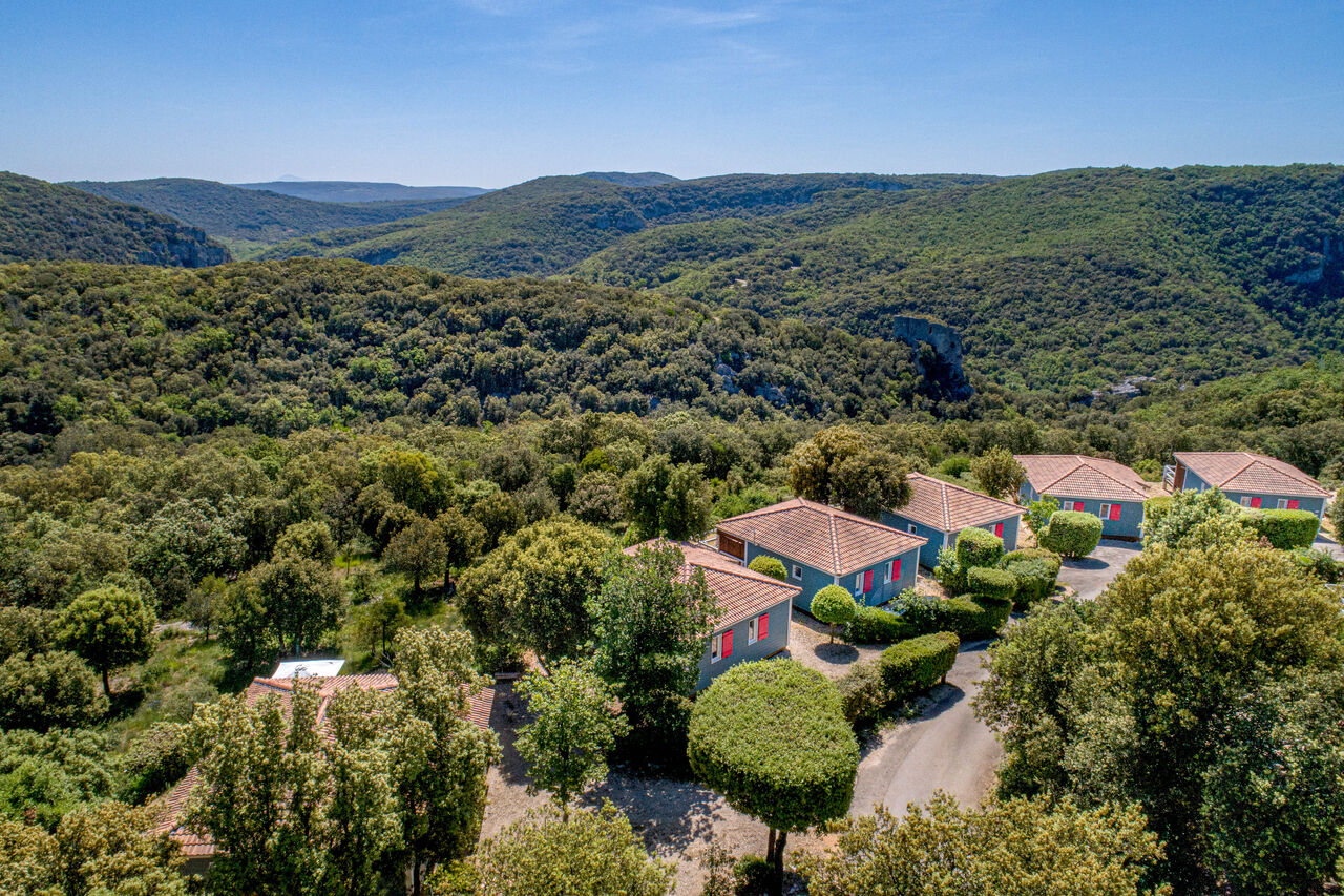 Chalets bleus avec toits tuiles au milieu nature, camping LIBRANOO Naturiste Sabliere � Barjac (30).