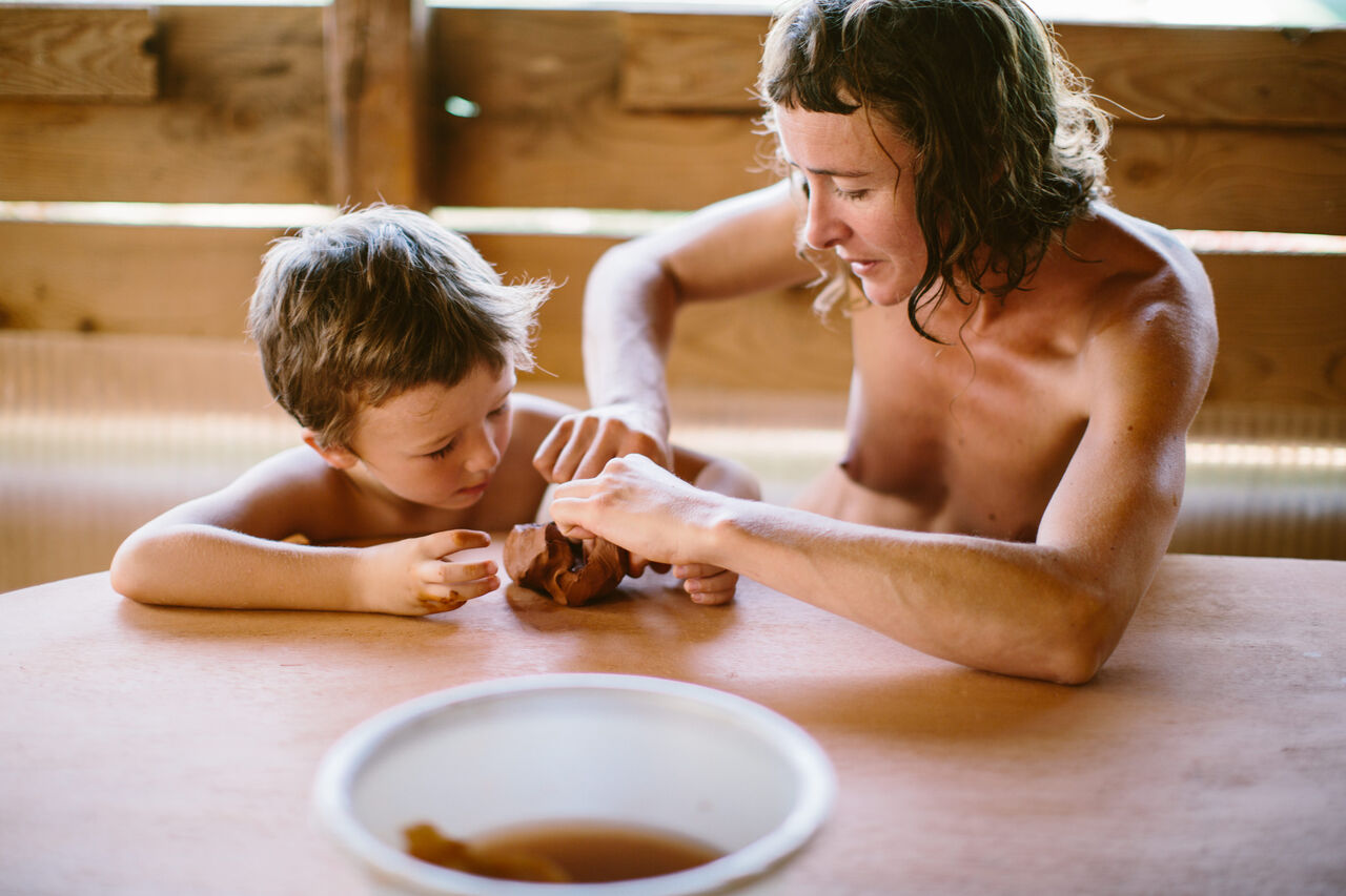 Enfant et adulte naturistes modelant au camping LIBRANOO Naturiste Sabliere � Barjac (30).