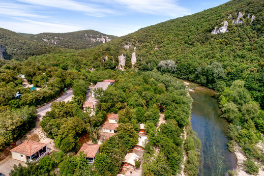 Luchtfoto van camping LIBRANOO Naturiste Sabliere met stacaravans en rivier.