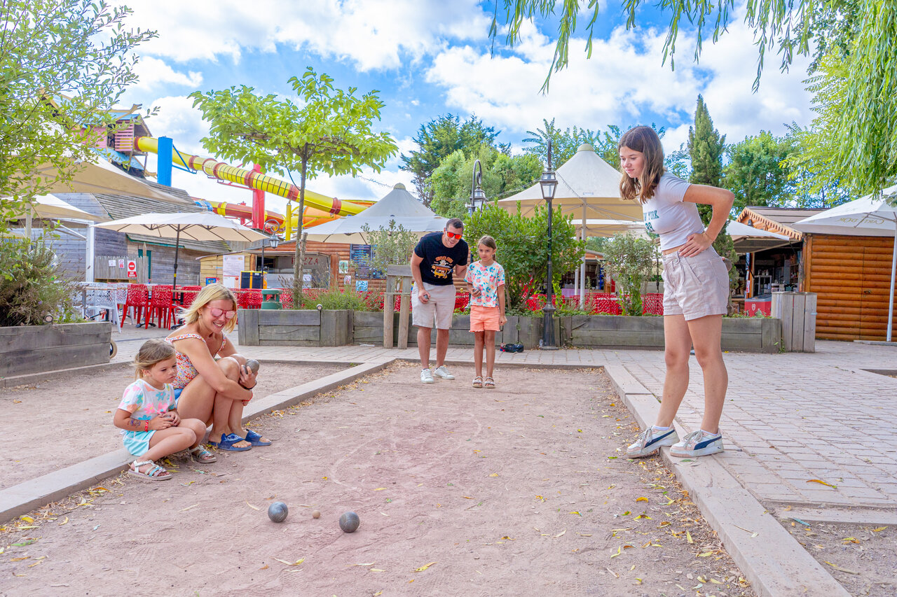 Familie spielt Boule, Wasserrutsche, auf dem Campingplatz CAPFUN Donjon de Lars.