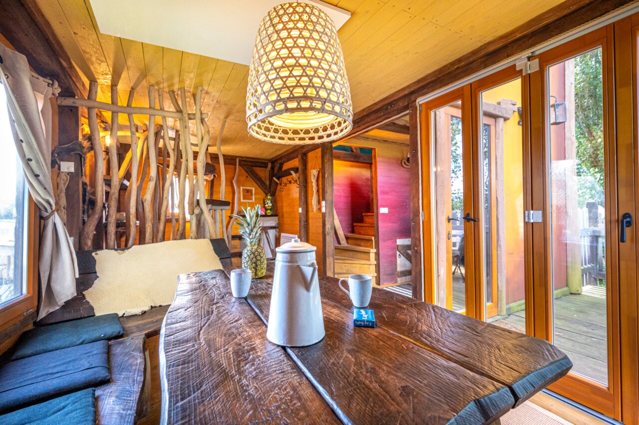 Rustikales Baumhaus-Interieur, Holztisch, auf dem Campingplatz CAPFUN Donjon de Lars: Baumh�user in Courseulles-sur-Mer (14).