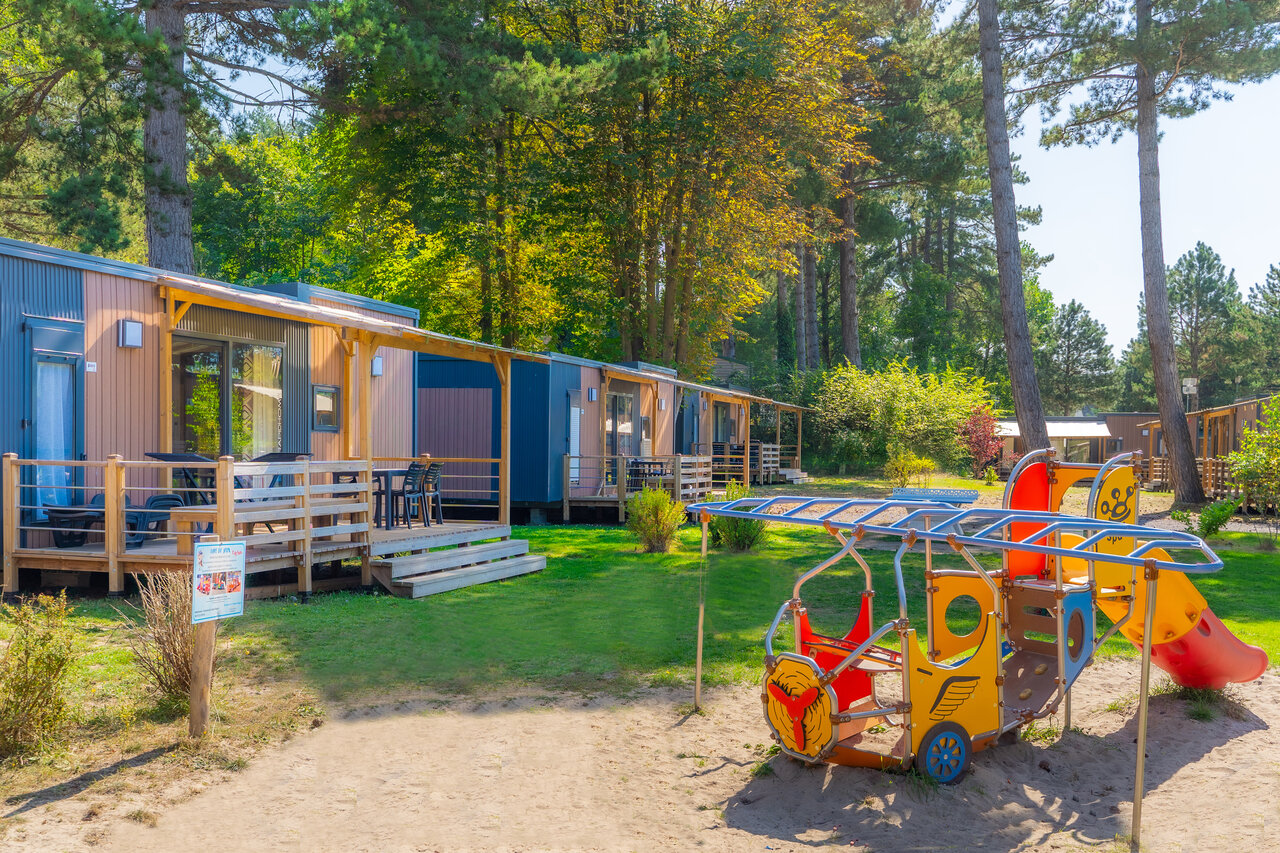 Modern mobile homes with terraces and playground at CAPFUN Dune Fleurie campsite in Quend Plage (80).
