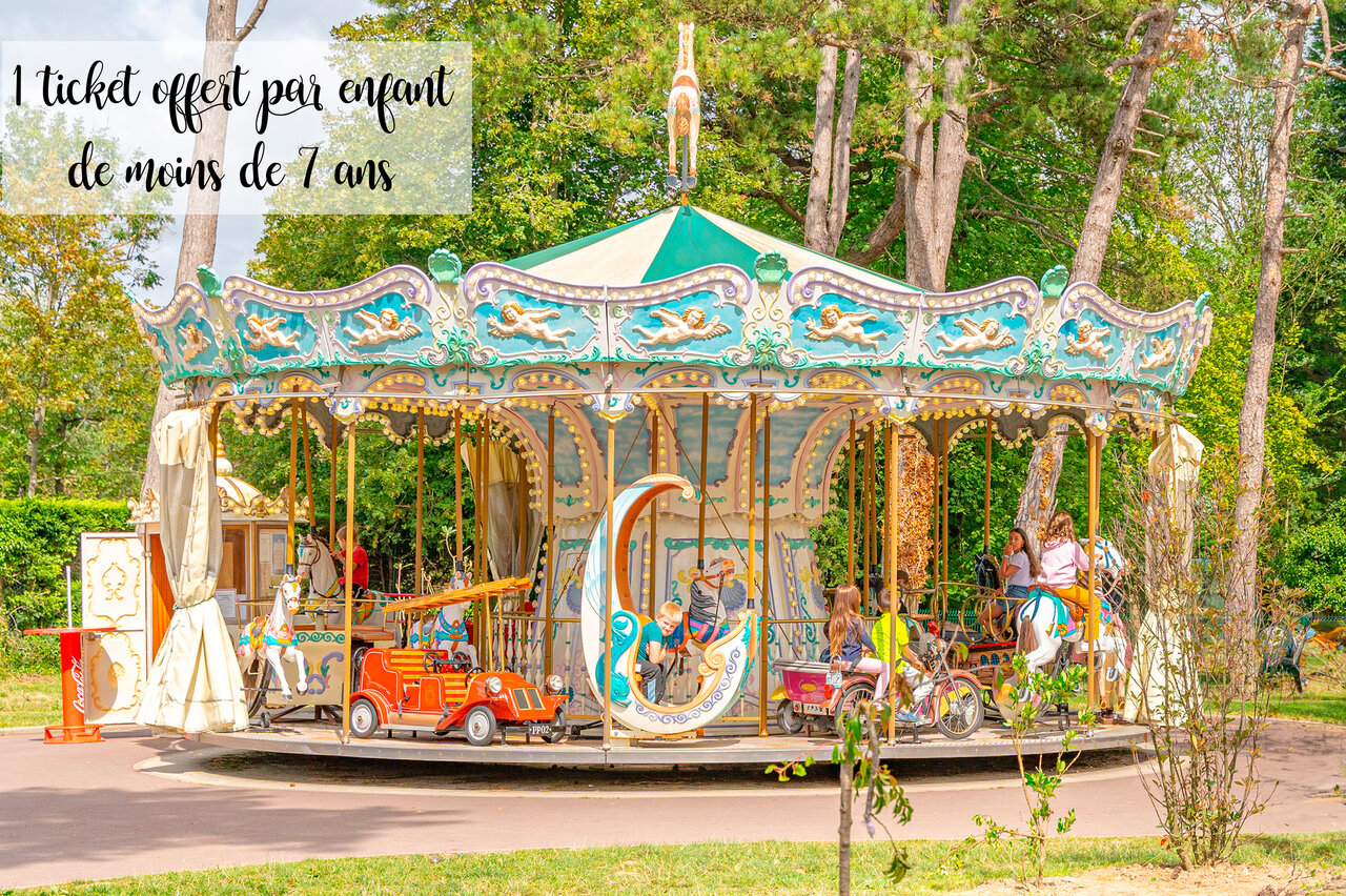Carousel with smiling children at CAPFUN Dune Fleurie campsite in Quend Plage (80).