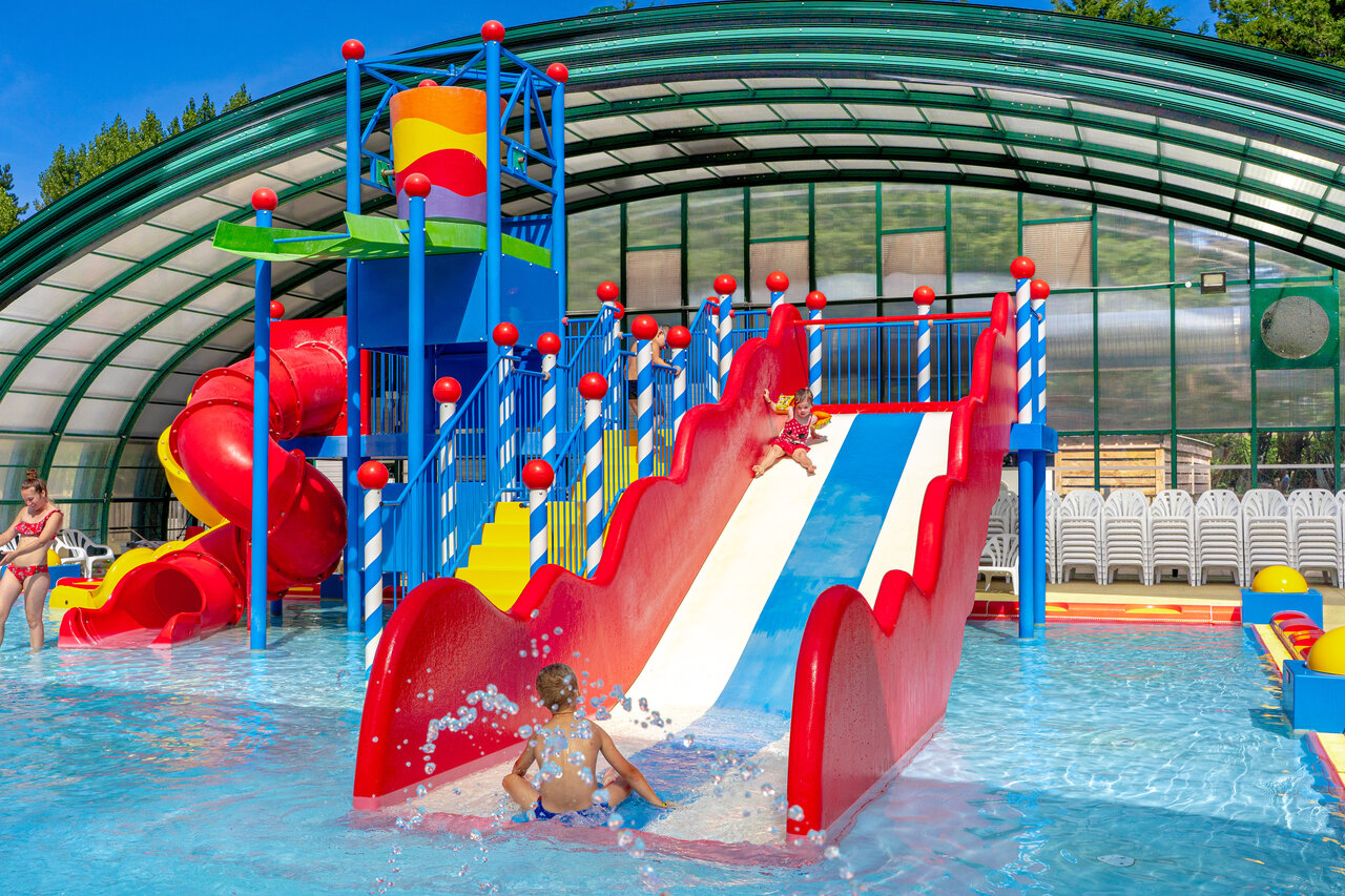 Slides and water games in covered pool at CAPFUN Dune Fleurie campsite in Quend Plage (80).
