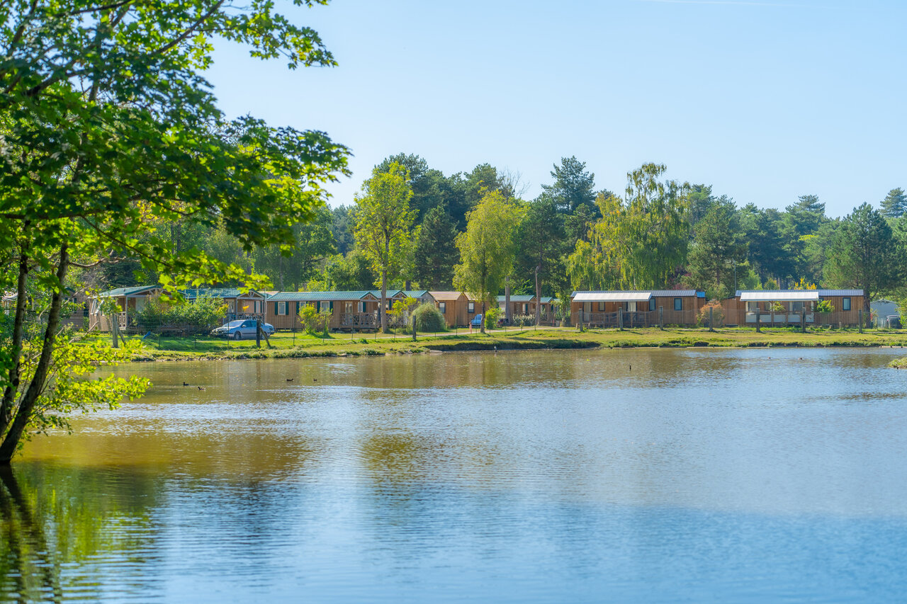 Mobile homes near lake at CAPFUN Dune Fleurie campsite in Quend Plage.