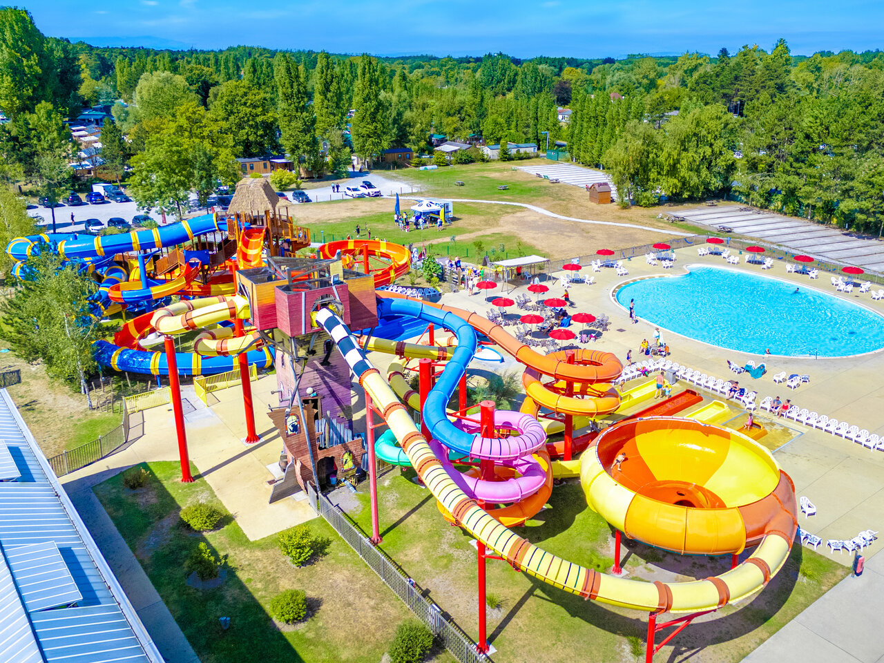 Colorful water slides and large outdoor pool at CAPFUN Dune Fleurie campsite in Quend Plage (80).