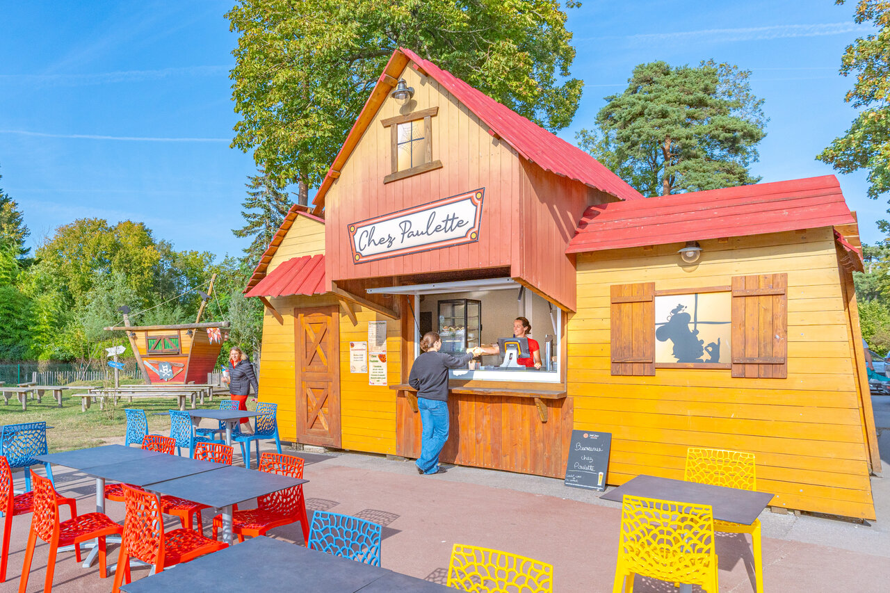Snack bar 'Chez Paulette', tables, playground at CAPFUN Dune Fleurie campsite.
