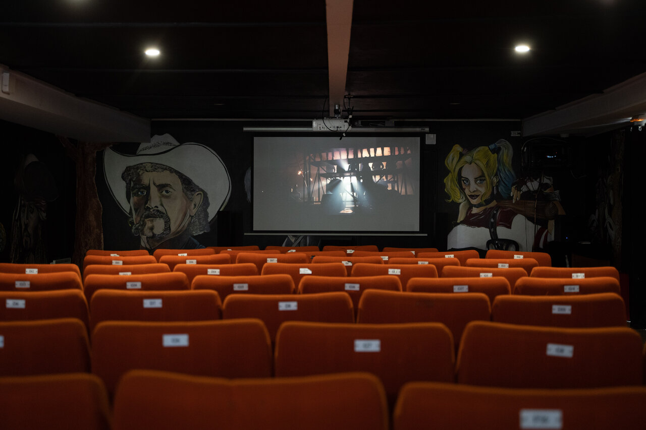 Cinema room, orange seats, large screen at CAPFUN Dune Fleurie (80).