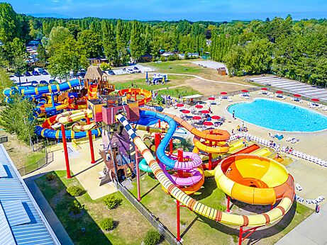 Bunte Wasserrutschen und gro�er Au�enpool aus der Vogelperspektive auf dem Campingplatz CAPFUN Dune Fleurie in Quend Plage (80).