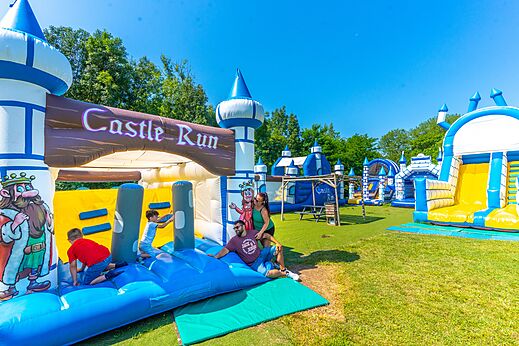 Gigantisch opblaasbaar speelpark met glijbanen en parcours op camping CAPFUN Duravel.