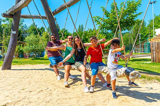 Familie auf großer Seilschaukel auf dem Campingplatz CAPFUN Duravel.