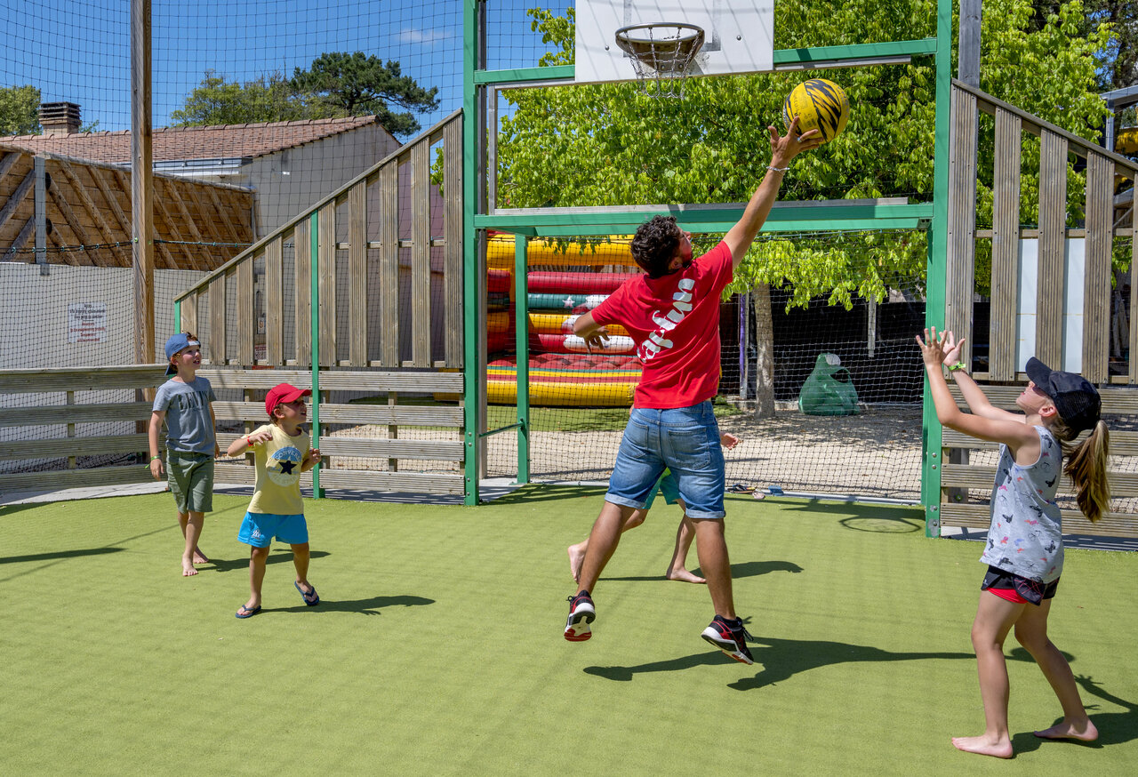 Animateur und Kinder spielen Basketball auf Multisportplatz CAPFUN Ecureuils JARD SUR MER (85).