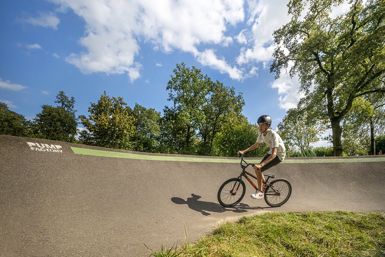 Junger Radfahrer auf Pumptrack mit BMX auf Campingplatz CAPFUN Eibernest in Eibergen.