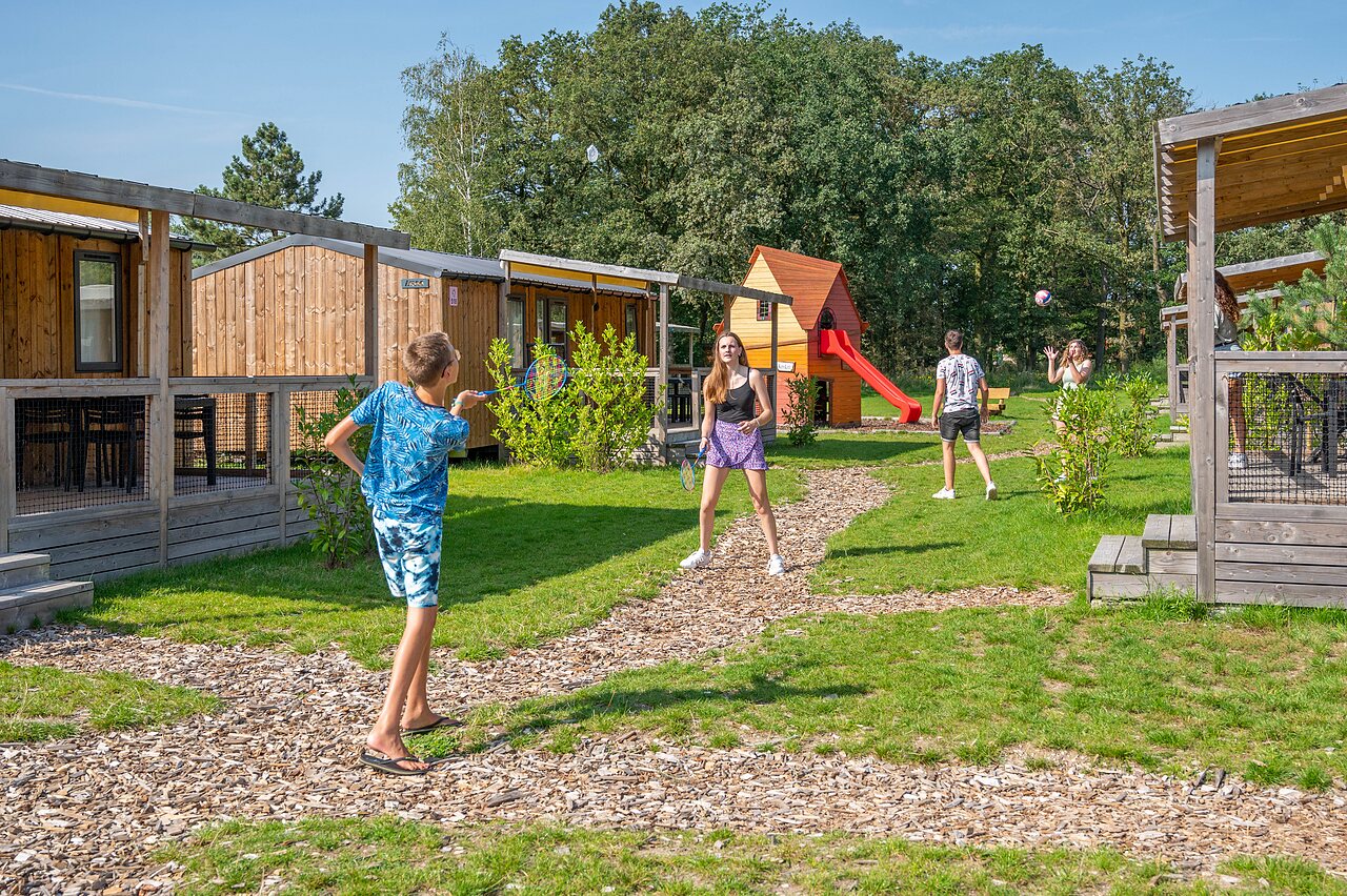 Kinder spielen Badminton nahe Mobilheimen auf Camping CAPFUN Eibernest in Eibergen.