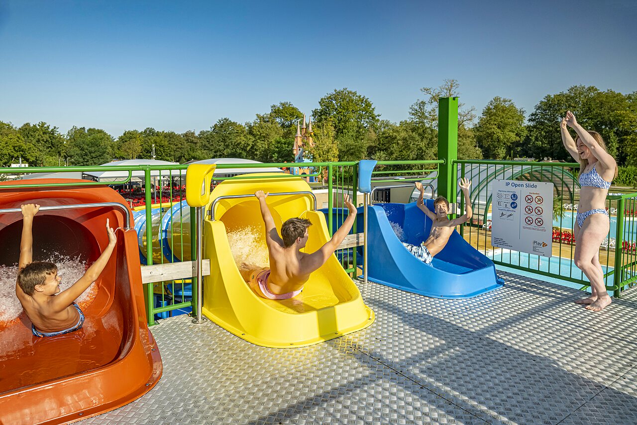 Kinder und Erwachsene haben Spa� auf farbigen Wasserrutschen auf dem Campingplatz CAPFUN Eibernest in Eibergen.