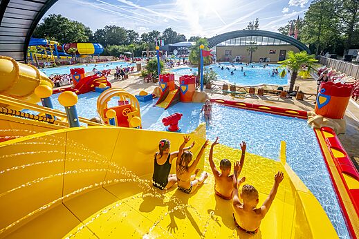 Kinder auf riesiger Wasserrutsche und Wasserspielen auf Camping CAPFUN Eibernest in Eibergen.