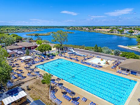 Piscine extérieure, toboggans et chaises au camping VAGUES OCEANES Elysée.