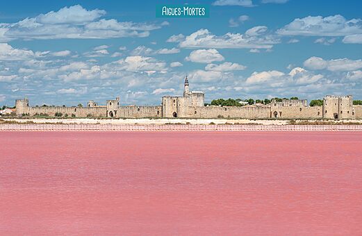 Historische Stadtmauern von Aigues-Mortes und rosa Salinen in der Camargue.