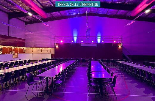 Salle d'animation avec tables au camping VAGUES OCEANES Elysée à Le Grau du Roi (30).