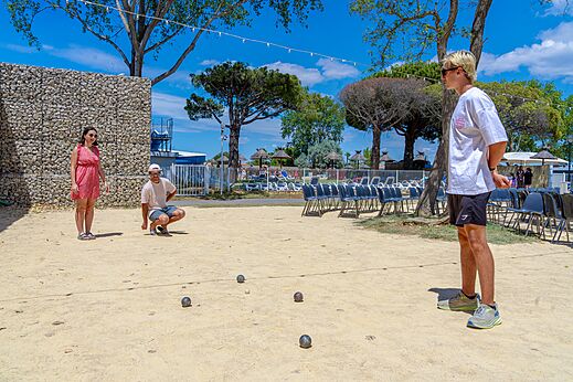 Terrain de pétanque avec joueurs au camping VAGUES OCEANES Elysée à Le Grau du Roi.