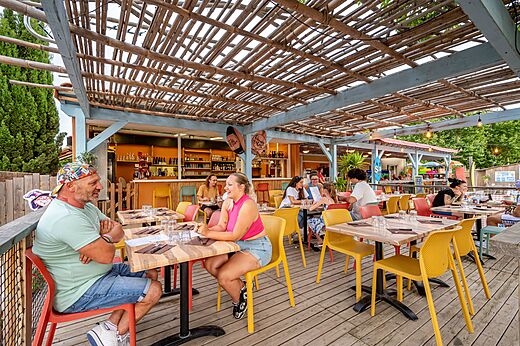 Restaurant et bar extérieur avec clients attablés au camping CAPFUN El Moli à Elne (66).