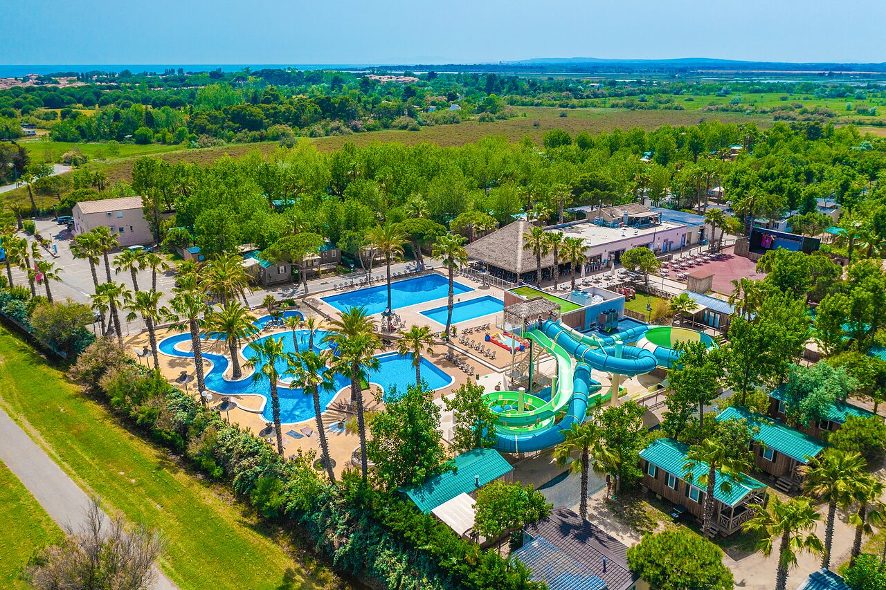 Grand parc aquatique avec toboggans et palmiers au camping CAPFUN Emeraude � Portiragnes (34).