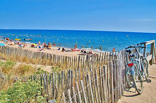 Feiner Sandstrand, Badeg�ste und Fahrr�der auf dem Campingplatz CAPFUN Emeraude in Portiragnes (34).