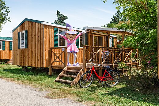 Wooden mobile home, mascot and bicycle at CAPFUN Emeraude in Portiragnes (34).