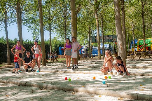 Familie spielt Boule auf einem schattigen Platz auf dem Campingplatz CAPFUN Emeraude in Portiragnes (34).