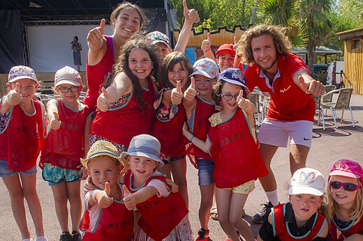 L�chelnde Kinder und Animateure mit erhobenen Daumen bei Animation auf Campingplatz CAPFUN Emeraude in Portiragnes (34).