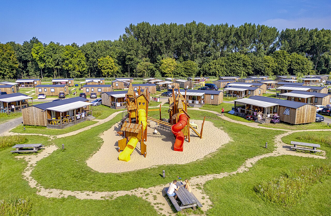 Speeltuin, stacaravans en groen op camping CAPFUN Erkemederstrand in Zeewolde.
