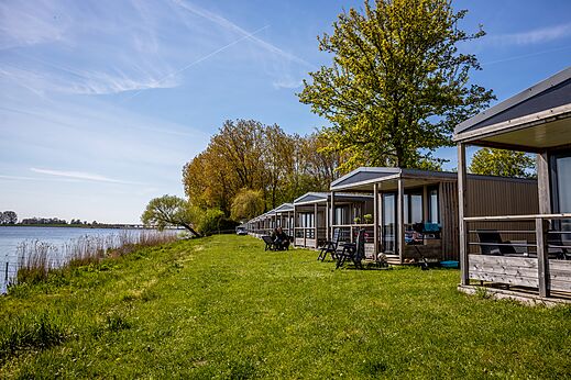 Moderne Mobilheime am Wasser, umgeben von Natur auf dem Campingplatz CAPFUN Erkemederstrand in Zeewolde.