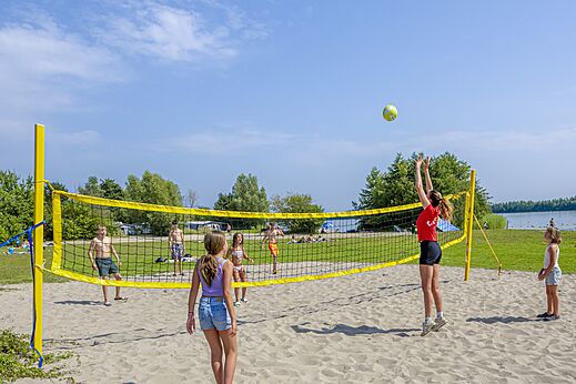 Beachvolleyballspiel am Strand mit Kindern auf dem Campingplatz CAPFUN Erkemederstrand in Zeewolde.