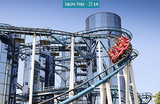 Blauwe achtbaan met rode wagen en passagiers in Europa Park, attractiepark.