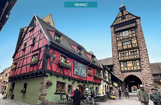Farbige Fachwerkh�user und mittelalterlicher Uhrturm in Ribeauvill�, Elsass.
