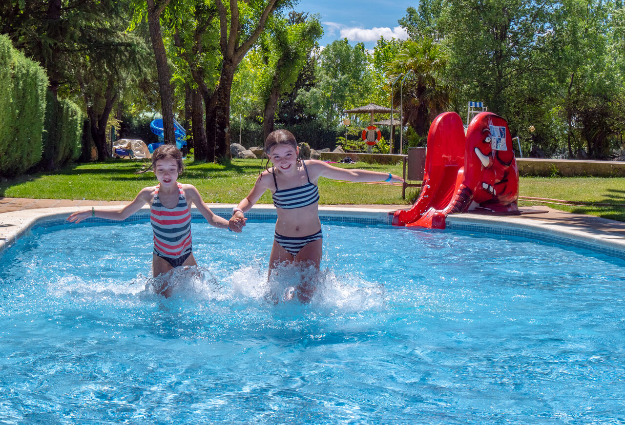 Piscina exterior con tobog�n y ni�os en el camping CAPFUN El Escorial, Madrid.