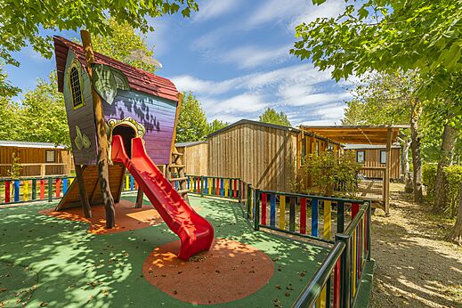 Spielplatz mit bunter Rutsche und Spielstruktur auf dem Campingplatz CAPFUN El Escorial in El Escorial, Madrid.